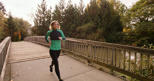 Woman sitting on footbridge