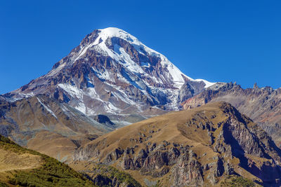 Scenic view of mountains against clear blue sky