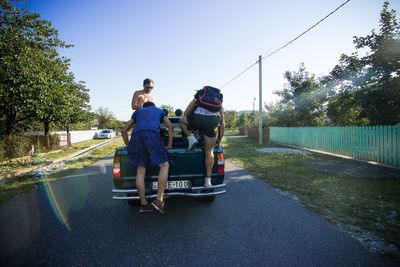 Rear view of people on road against sky