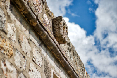 Low angle view of stone wall against sky