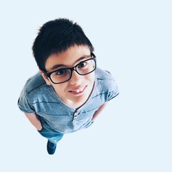 High angle portrait of boy standing on white background