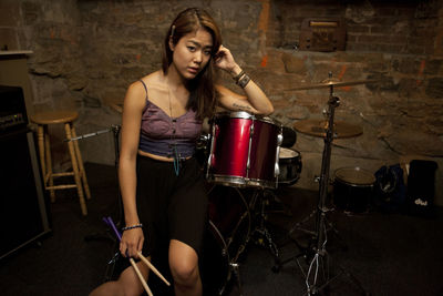 Young woman standing by her drum kit