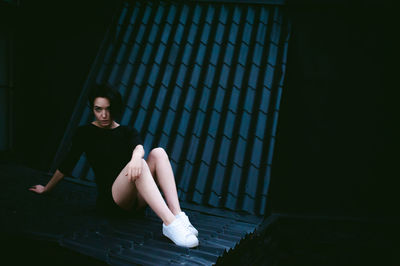 Beautiful young woman sitting on roof