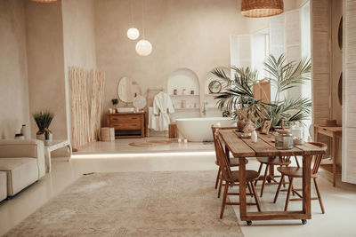 Luxury interior of big bathroom at modern african style with oval bathtub in natural lighting