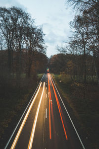 Road amidst trees in forest against sky