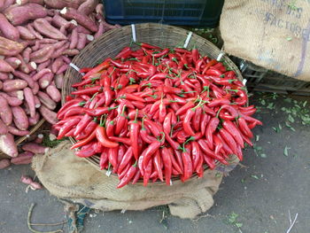 High angle view of red chili peppers in basket at market for sale