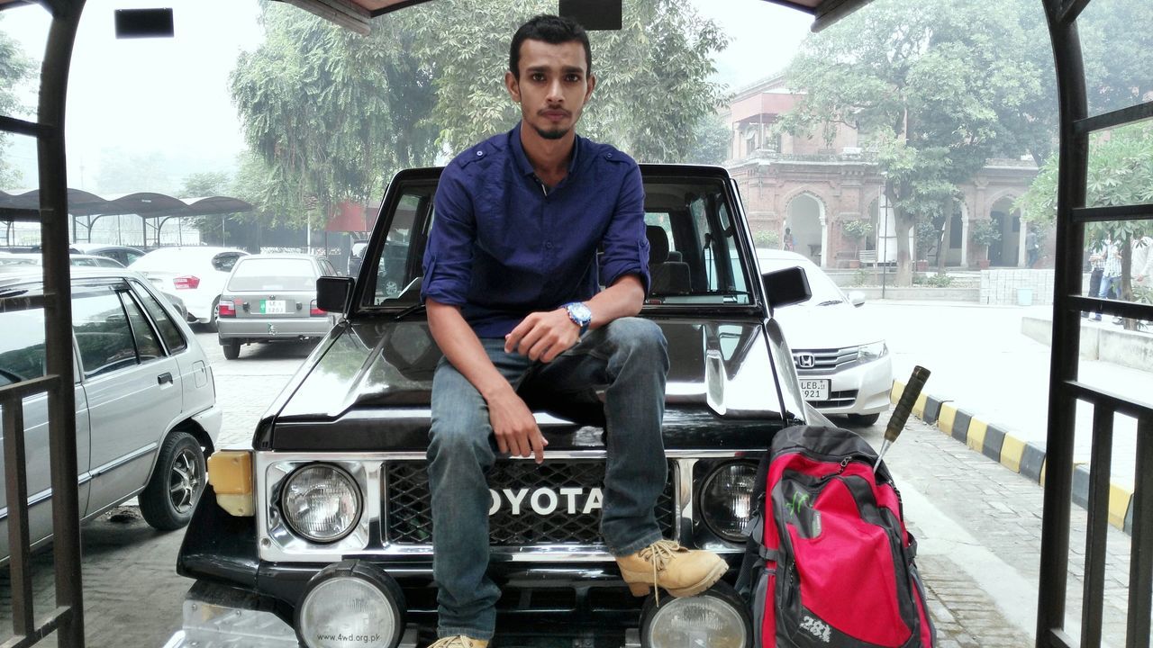 lifestyles, transportation, mode of transport, leisure activity, young men, casual clothing, young adult, land vehicle, front view, person, car, travel, men, holding, sitting, looking at camera, standing, three quarter length