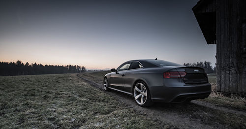 Car on field against sky during sunset