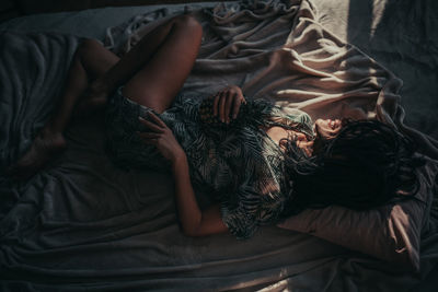 High angle view of woman relaxing on bed at home