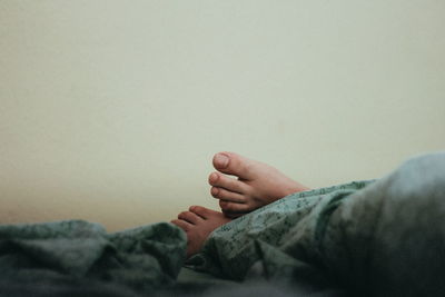 Close-up of feet under blanket