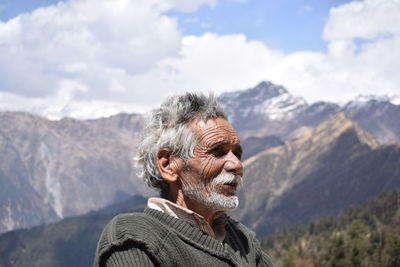 Senior man standing against mountain