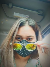 Portrait of woman wearing sunglasses in car