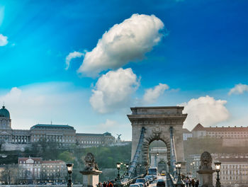 Statue in city against cloudy sky