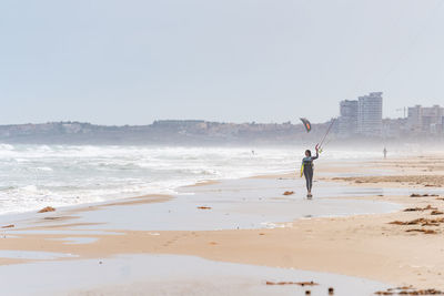 Full length of man on beach against clear sky