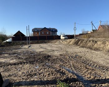 Houses by land against clear blue sky