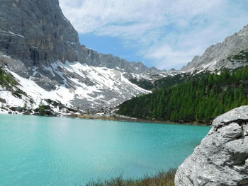 Scenic view of lake by mountains against sky