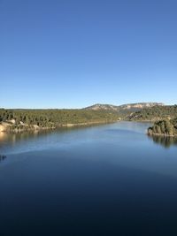 Scenic view of lake against clear blue sky