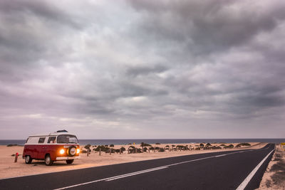 Car on road against cloudy sky