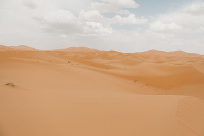 Sand dunes at desert against sky