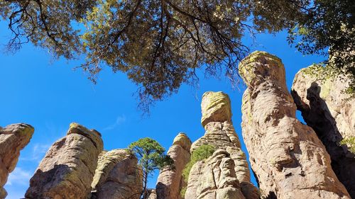 Low angle view of rocks against blue sky