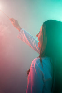 Cheerful woman holding illuminated sparkler 