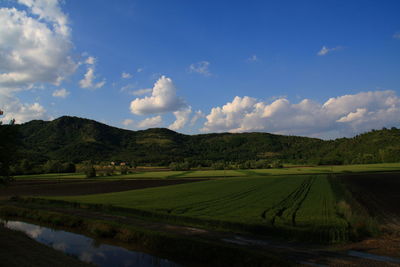 Scenic view of field against cloudy sky