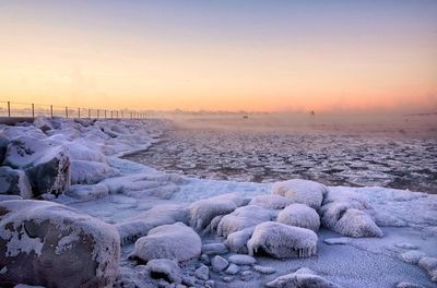 Scenic view of frozen sea against clear sky during sunset