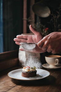 Midsection of person with cake on table