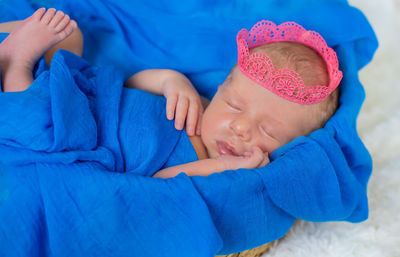 Portrait of cute baby girl lying on snow