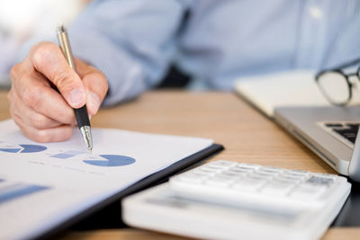 Close-up of man using mobile phone on table