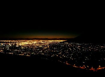 Aerial view of illuminated cityscape against sky at night