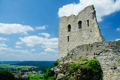 Old ruins by landscape against sky