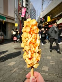 Person holding ice cream on street