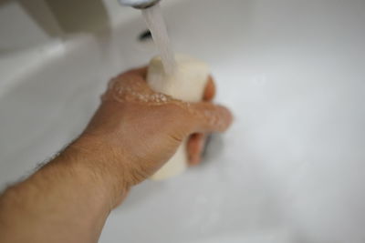 Midsection of person hand in bathroom at home