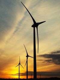 Low angle view of silhouette windmill against sky during sunset