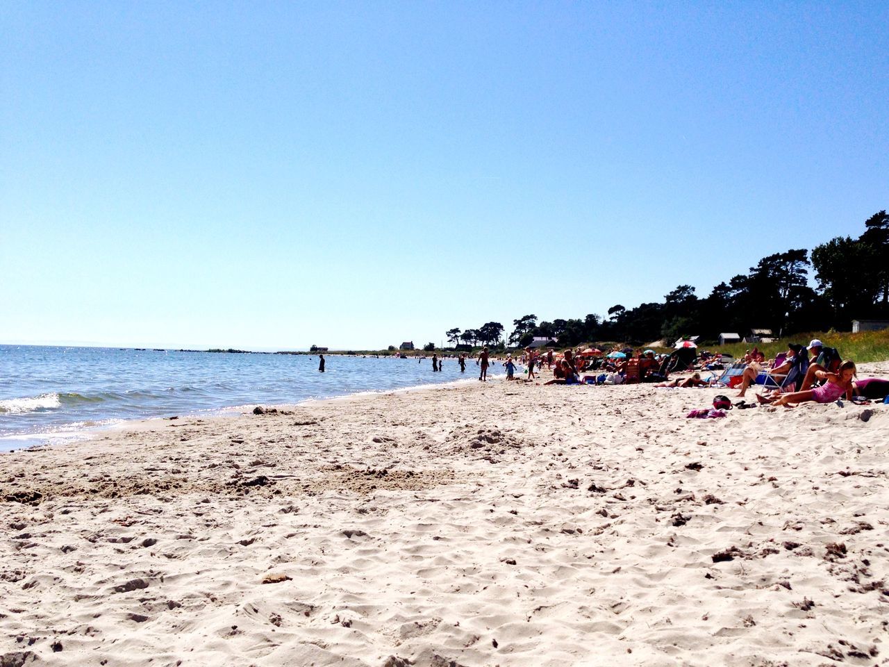 beach, clear sky, sand, sea, copy space, shore, water, horizon over water, large group of people, tranquil scene, blue, vacations, tranquility, scenics, beauty in nature, nature, beach umbrella, incidental people, summer