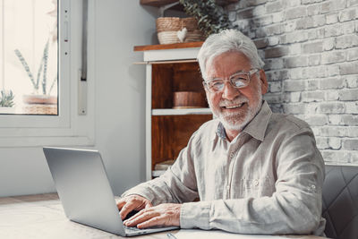 Senior man using laptop at home