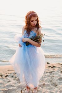 Beautiful young woman standing at beach