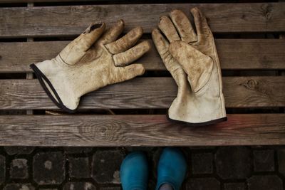 Low section of gloves lying on wooden bench