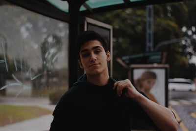 Portrait of young man looking through window