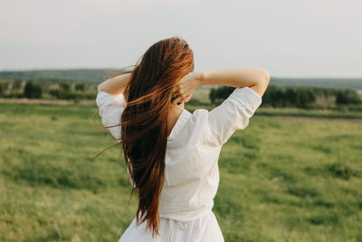 Rear view of woman standing on field