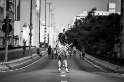 Rear view of woman walking on street in city