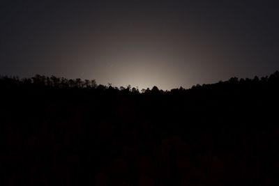 Silhouette landscape against clear sky at night