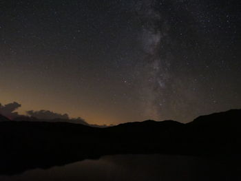 Scenic view of silhouette mountain against star field