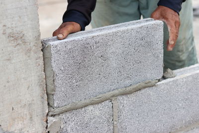 Midsection of construction worker making concrete wall
