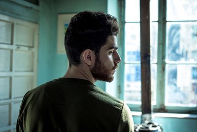 Rear view of young man standing at home