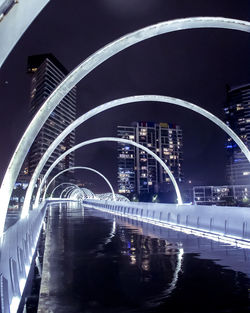 Bridge over river in city at night