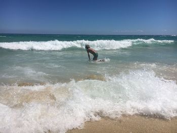 Man surfing on sea against sky