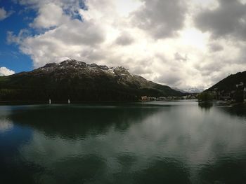 Scenic view of lake by mountains against sky