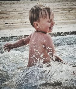 Shirtless boy playing in sea